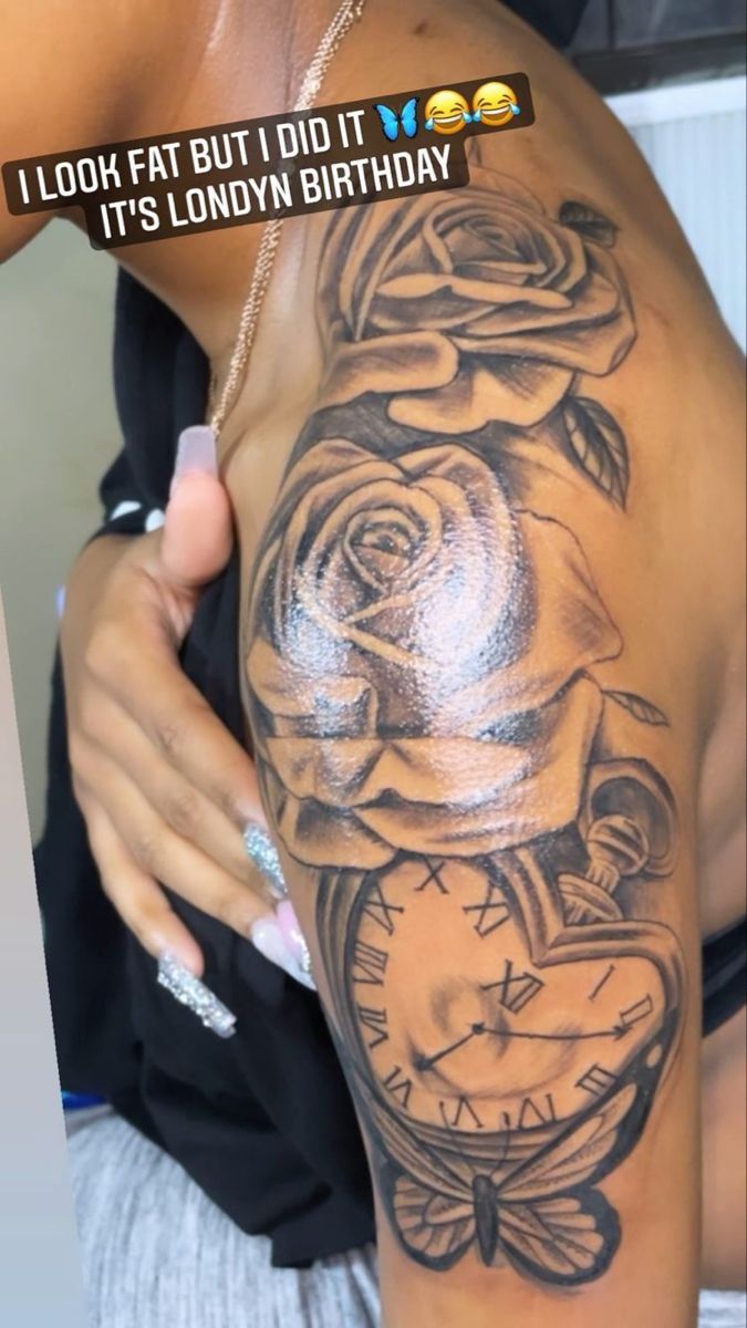 a woman with a tattoo on her arm holding a clock and roses in the background