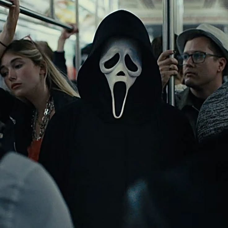 a group of people on a bus with a ghost mask covering their faces and hands