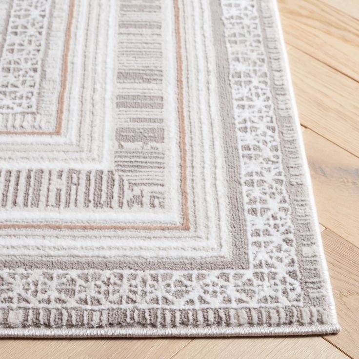 a close up of a rug on a wooden floor with wood floors and white walls