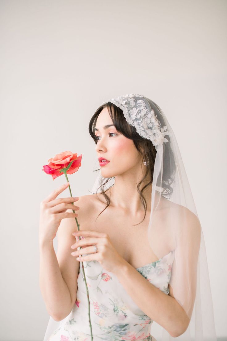 a woman in a wedding dress holding a flower