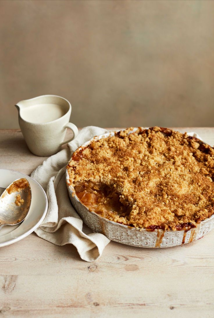 a pie sitting on top of a white plate next to a cup and saucer