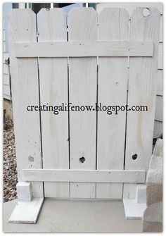 a white wooden fence sitting on top of a sidewalk