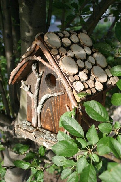 a bird house made out of logs in the woods