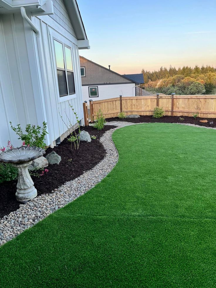 a backyard with artificial grass and landscaping