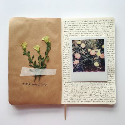 an open book with flowers and writing on it