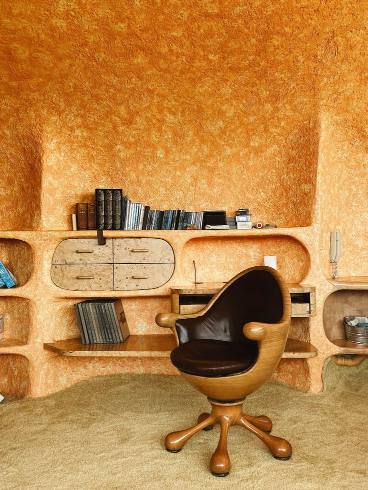 a chair sitting in front of a book shelf filled with books