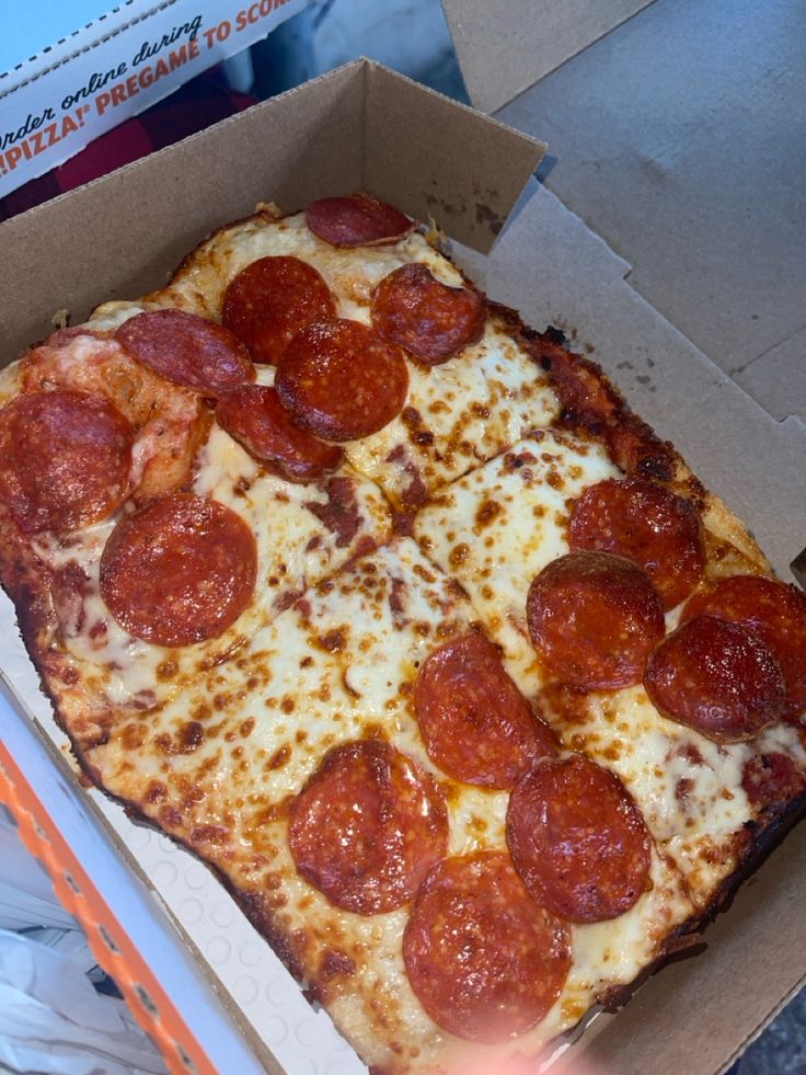 a pepperoni pizza in a box on the table