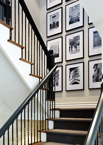 a staircase with pictures on the wall and carpeted stairs leading up to the second floor