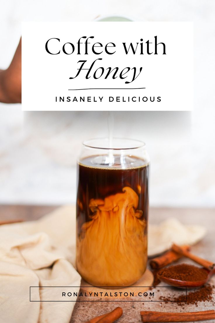 coffee with honey is being poured into a glass mug on a table next to cinnamons