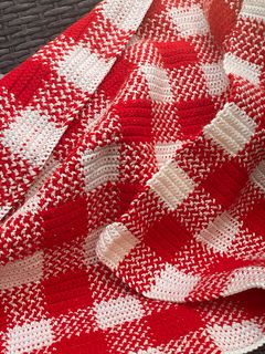 a red and white blanket sitting on top of a table