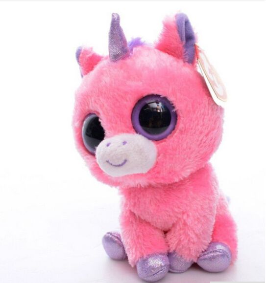 a pink stuffed animal with big eyes and a horn on it's head, sitting against a white background