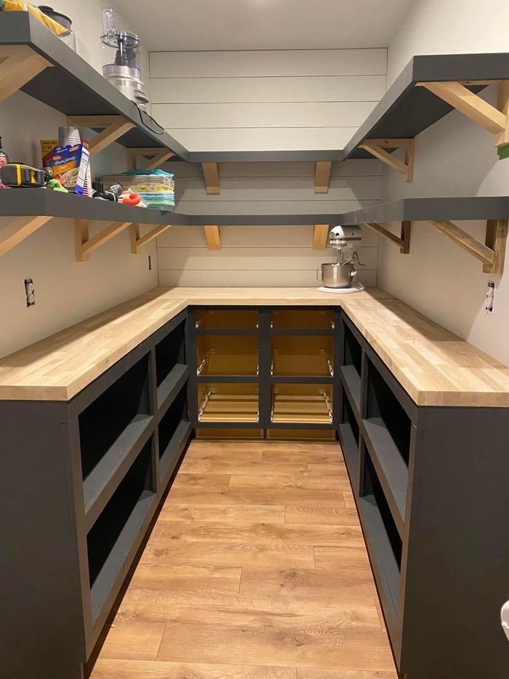 an empty kitchen with shelves and wooden floors