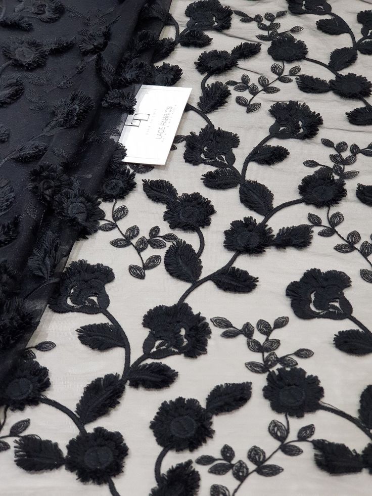 black floral embroidered lace fabric on white background