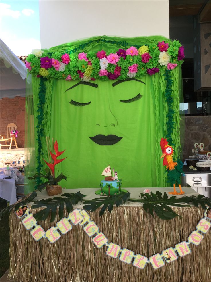 a green face with flowers on top of it and decorations around the edges for decoration