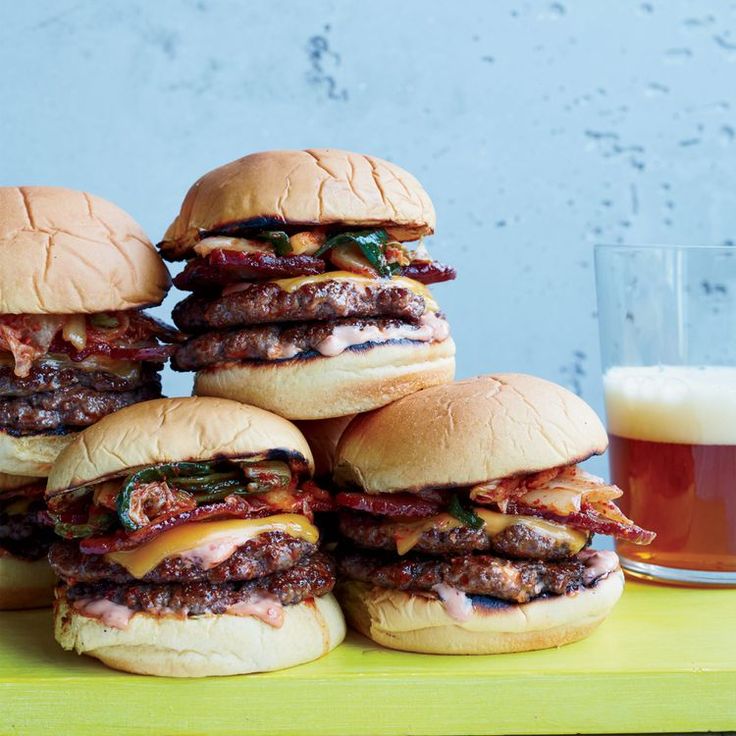 five hamburgers and a glass of beer on a table