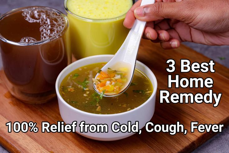 a person holding a spoon over a bowl of soup and two cups of cold beverages