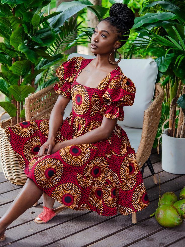 Boasting a stylish square neckline and a tiered skirt, the Batik Dress offers comfort and a flattering silhouette with a fun, twirl-ready design. * sash belt not included Approx. 38" Length (center back) based on size M 100% Cotton. Colours: Multi-print (green, navy, ivory, black) Cotton lined bodice Back zipper closure African Print Smocked Dress, African Graduation Dress Style, African Summer Dress, Cute African Dresses, Vitenge Dresses Designs, African Style Dresses, Dresses African Fashion, Chitenge Dresses, Wax Dress