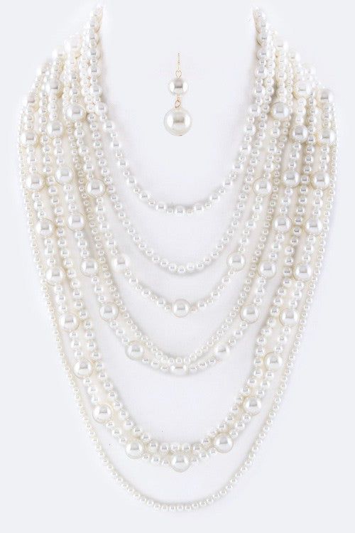 Enhance your everyday look with the stunning Million Pearls Layer Necklace Set. With layers of lustrous pearls, this set adds elegance and sophistication to any outfit. The perfect accessory for a night out or a special occasion. Elevate your style and make a statement with this beautiful necklace set. SPECIFICATIONS: Necklace - 17" + Extension Earrings - 1.85" Drop Lead & Nickel Compliant Elegant Multi-strand Pearl Beaded Necklaces, Elegant Multi-strand Pearl Beaded Necklace, Elegant Layered Pearl Necklace, Elegant Pearl Layered Necklace With Pearl Chain, Chic Pearl Beaded Necklaces For Party, Multi-strand Pearl Drop Necklaces For Party, Party Beaded Pearl Necklaces With Pearl Pendant, Glamorous Pearl Jewelry With Pearl Chain, Party Pearl Beaded Necklaces With Pearl Pendant