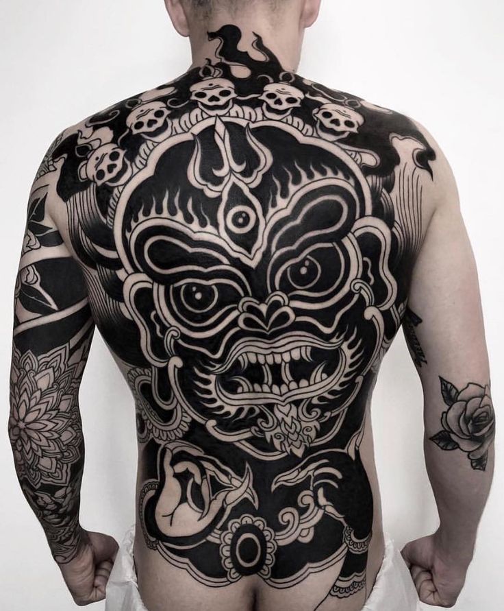 a man with tattoos on his back and chest