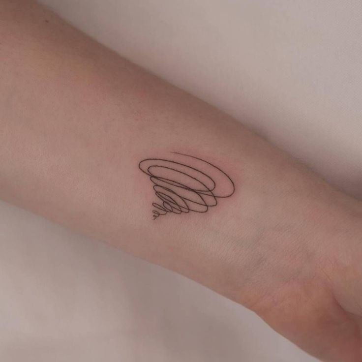 a woman's arm with a small tattoo on it