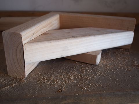 a wooden bench sitting on top of a piece of ply wood with no one around it