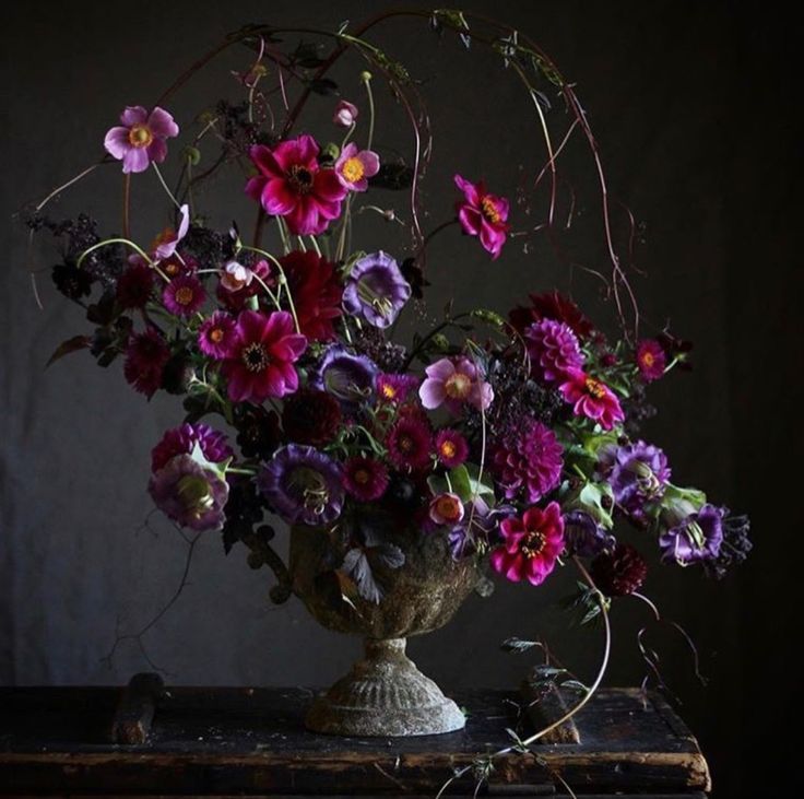 a vase filled with lots of purple and pink flowers