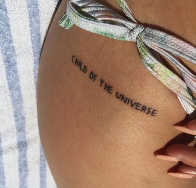 a woman's thigh with the words child of the universe written on her side