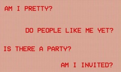 a red sign that says, am i pretty? do people like me yet? is there a party? am i united?