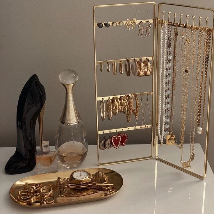 there is a gold jewelry rack and shoes on the table