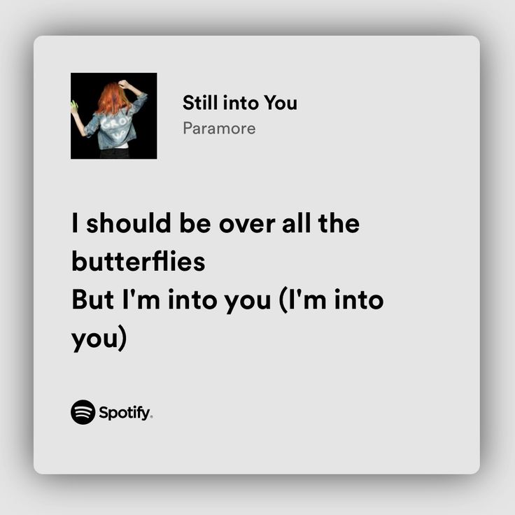 a woman with red hair standing in front of a white sign that says, i should't be over all the butterflies but i'm into you