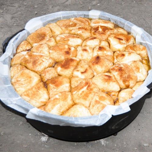 a pan filled with food sitting on top of a cement ground