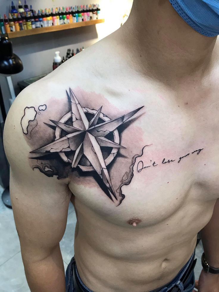 a man with a compass tattoo on his chest