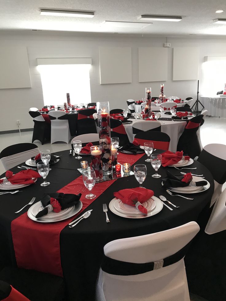 a banquet room set up with black and red linens