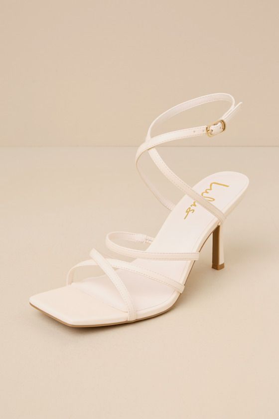 Making any look more glamorous is easy when you have the Lulus Skyy Beige Strappy High Heel Sandals! Smooth faux leather shapes these stunning heels that feature a trendy square footbed, crisscrossing toe straps, and a slender vamp strap (with elastic at the side for fit). Matching straps cross at the front and secure around the ankle with a gold buckle, all atop a stiletto heel. 3. 25" wrapped stiletto heel. Cushioned insole. Rubber sole has nonskid markings. Man made materials. Imported. Lulus Party Heels With Straps And Square Toe, Summer Evening Heels With Crisscross Straps, Evening Open Toe Sandals With Crisscross Straps, Evening Sandals With Crisscross Straps And Open Toe, Chic Sandals With Crisscross Straps And Open Toe, Open Toe Heels With Crisscross Straps For Evening, Evening Open Toe Heels With Crisscross Straps, Evening Heels With Crisscross Straps And Open Toe, Elegant Summer Heels With Crisscross Straps