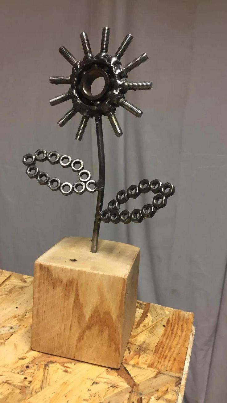 a metal sculpture on top of a wooden block