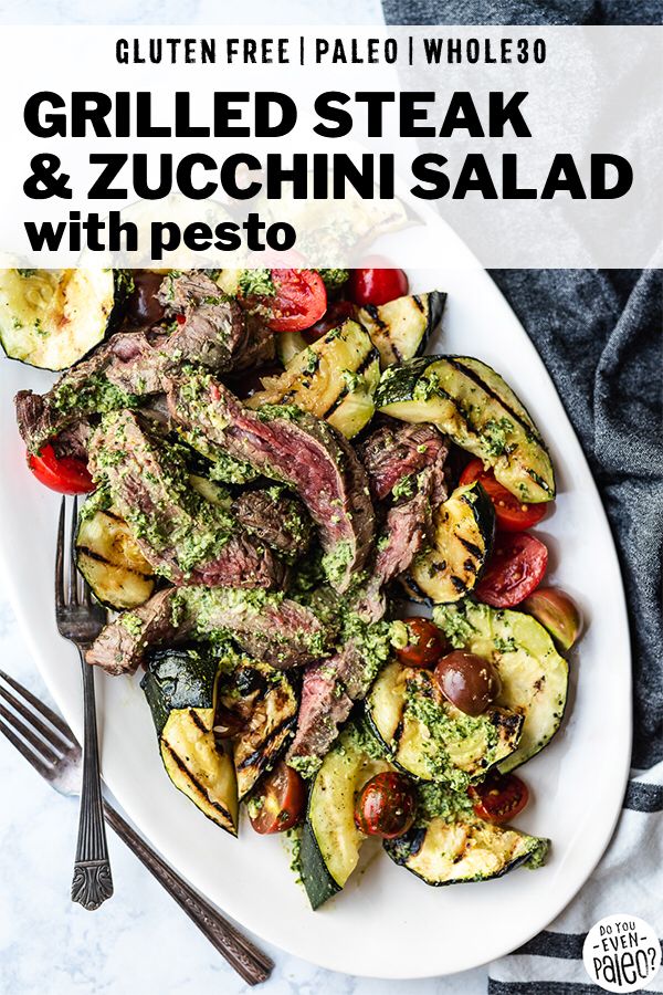 grilled steak and zucchini salad with pesto on a white platter