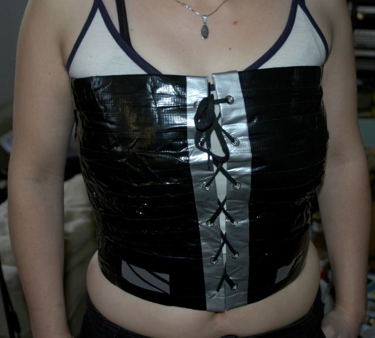 a woman wearing a black and white corset with silver strips on the side