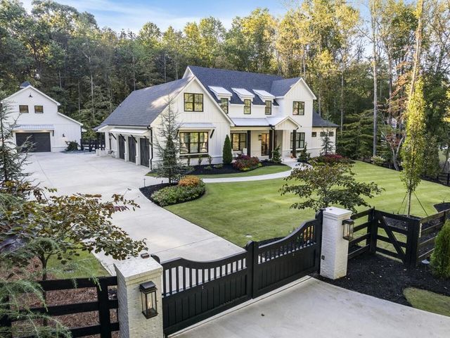 a large white house surrounded by trees and grass