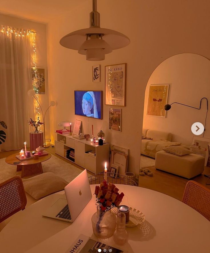 a laptop computer sitting on top of a table in front of a tv set and couch