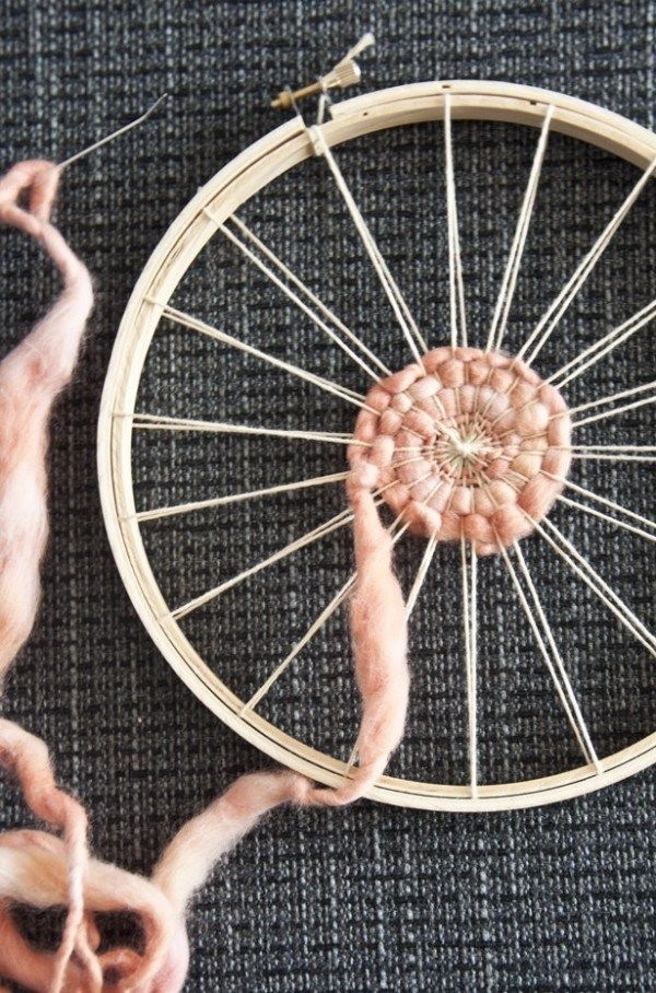 a close up of a weaving machine with yarn on the ground next to it,