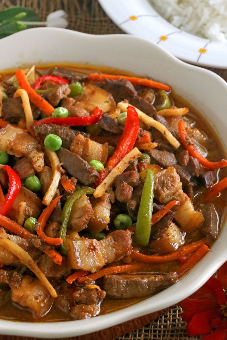 a white bowl filled with meat and vegetables