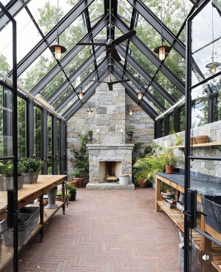 the inside of a greenhouse with tables, benches and an open fire place in it