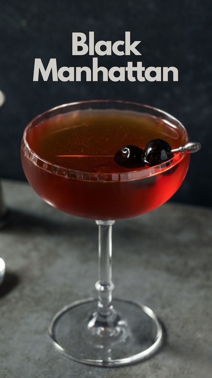 the black manhattan cocktail is garnished with an olive