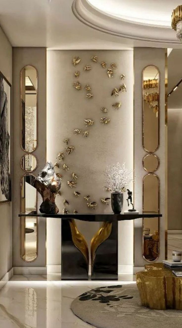 an elegant living room with gold accents and mirrors on the wall, along with a black table