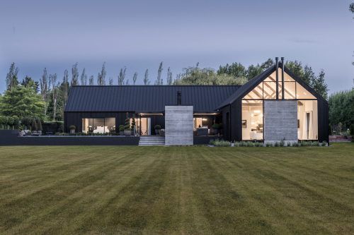 a modern house in the middle of a grassy field