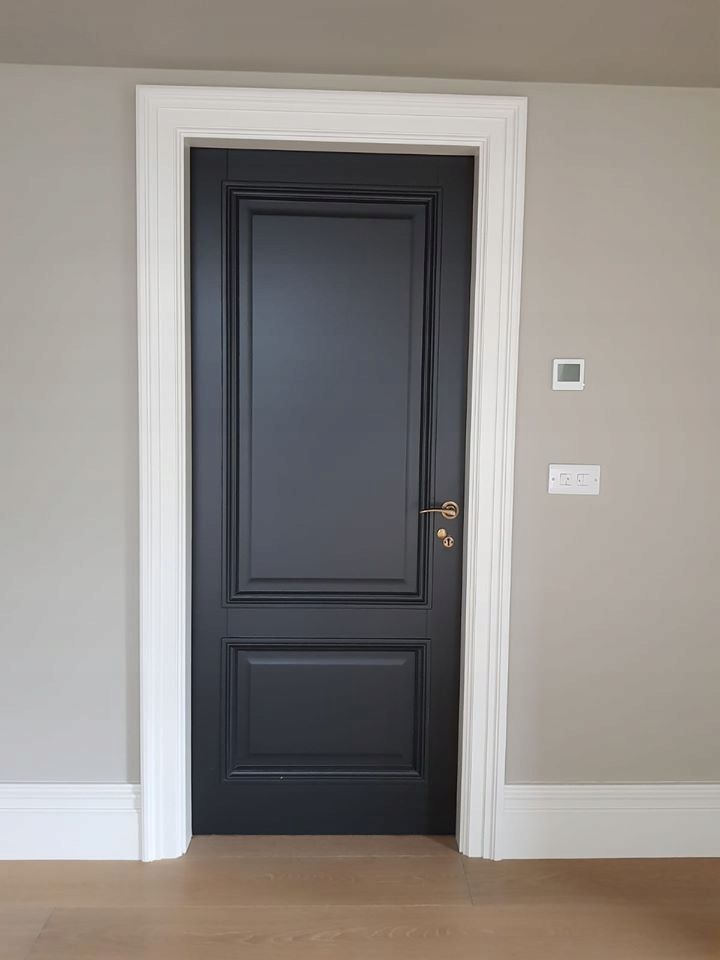 an empty room with a black door and white trim