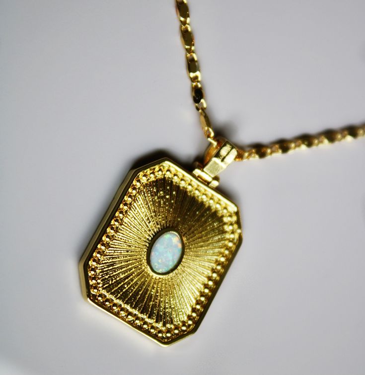 The Opal Sunburst Necklace features a medium sized rectangle tag pendant with a bezel-set, white Opal gemstone on a unique gold-filled flat chain. Materials: 18k Brazilian Gold-Filled Chain & Findings Pendant Measurements: 25mm x 20mm Chain Width: 2mm Chain Length: 18” inches Gemstone: Lab Created White Opal Gold-filled jewelry is durable, fade/tarnish resistant. Avoid coming in contact with chemicals, chlorine and saltwater. Store in protective pouch when not in use. Sunburst Necklace, Brazilian Gold, White Opal, Gold Filled Jewelry, Gold Filled Chain, Opal Gemstone, Bezel Setting, Chain Lengths, Chain Length