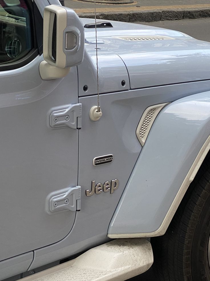 the jeep is parked on the side of the road with its door open and it's front window partially closed