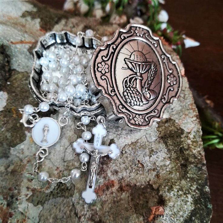 "Handmade 1st communion rosary for boy or girl. Made with white 6 mm pearl beads and silver tone links. Rosary features white St Benedict crucifix and centerpiece with Holy Communion Chalice. Comes in a beautiful metal box with communion symbol and engraved letters JHL- which stand for Jesus Hominum Salvator (Latin: Jesus Savior of Mankind). A perfect gift for occasion such as Wedding, Baptism, Confirmation, First communion... Made in and shipped from Medjugorje. Message card of Holy Lady from M Personalized Silver Rosary For First Communion, Personalized Silver Rosary For Confirmation, Handmade Silver Rosary Bracelet For First Communion, Silver Spiritual Rosary Bracelet For First Communion, Spiritual Silver Rosary As Gift, Handmade Silver Rosary For Baptism, Pearl White Rosary With 8mm Beads As Gift, Silver Spiritual Jewelry For Baptism, Silver Rosary For Baptism