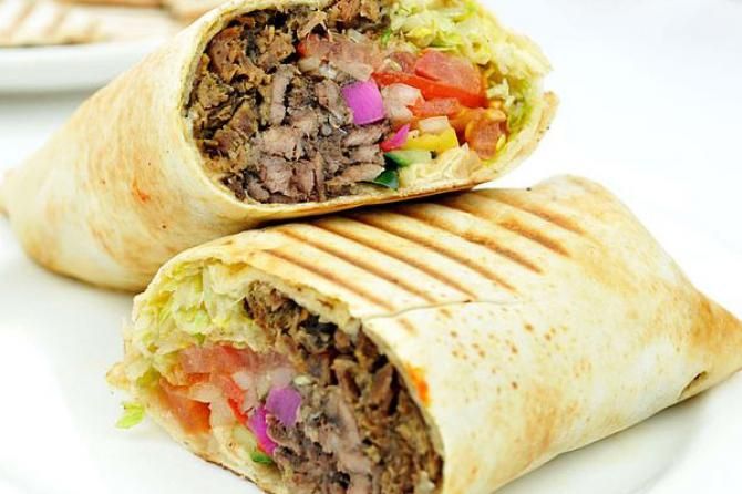 two burritos are stacked on top of each other with meat and veggies